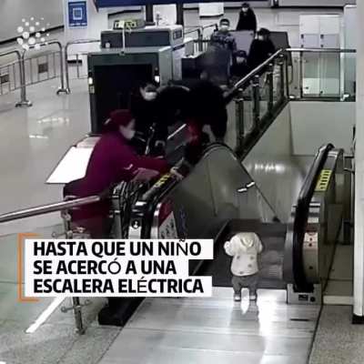 Security guy saving a child from falling down an escalator