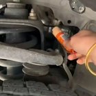 A very vocal kitten being lured out from under the hood of a car to be rescued