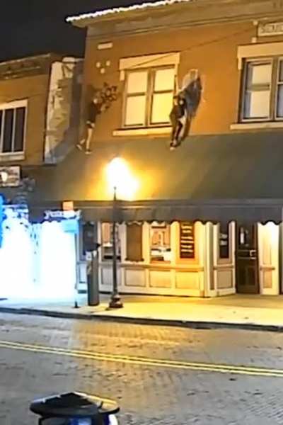 WCGW standing on a canopy to graffiti a building