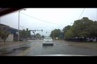 This guy reverses through an intersection in front of a cop.