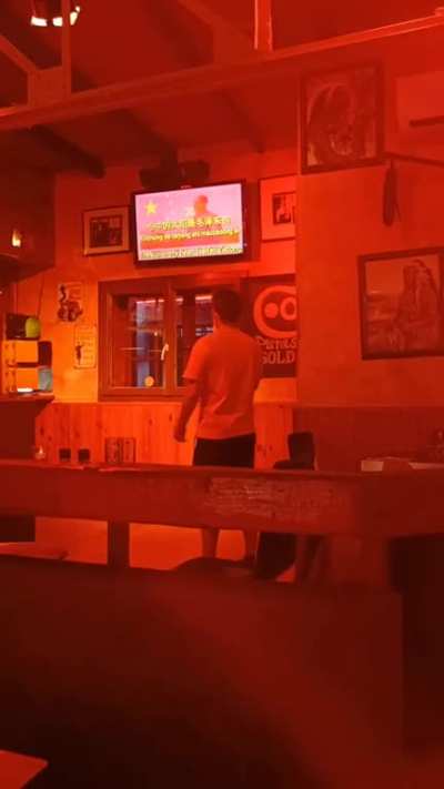 German kid singing Chinese propaganda song in an American-themed karaoke bar in France