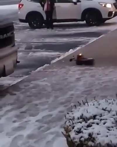 A toy plow truck clearing snow at a strip mall.