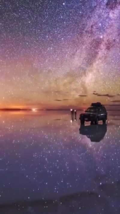 ? Timelapse footage was filmed at Salar de Uyuni, the largest salt flat in the world, hidden deep in the Andes in southwest Bolivia. At the start of rainy season, water doesn't absorb into the ground quickly creating a gigantic reflective "lake"