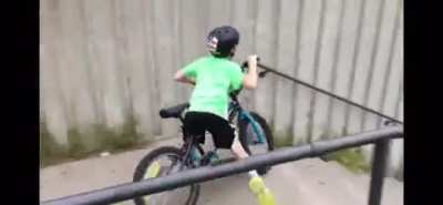 Kid tries to ride his bike down a long set of steps and yells "Call 911!" when he realize he was going to crash.