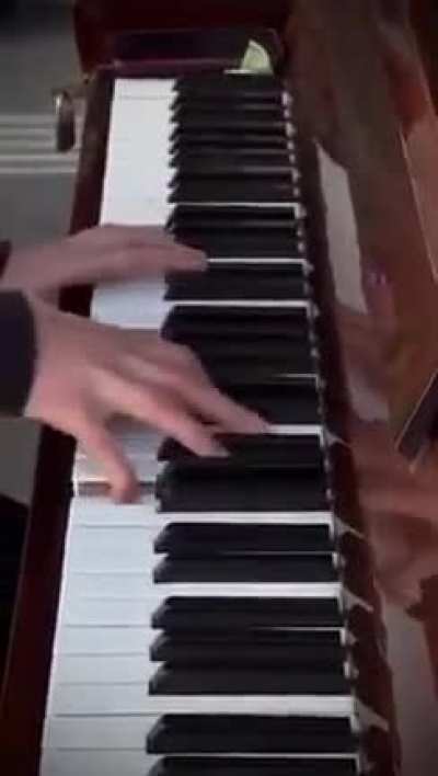 Pianist playing Hans Zimmer's Time in the streets of Kyiv while the air raid sirens wail.