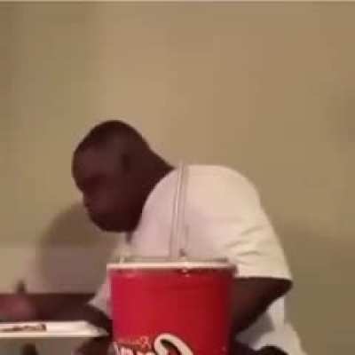 Just a guy enjoying his chicken, with a side of Coke...