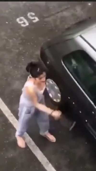 Angry woman attacks car with a knife and a hammer, gets taken out by a dude
