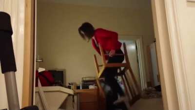 Standing on two chairs on top eachother to change the lightbulb