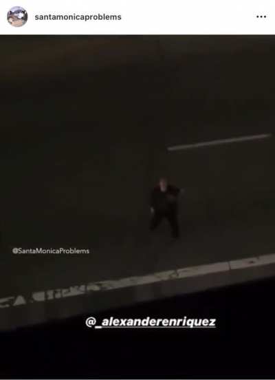 Guy screaming at a building while standing in the middle of the road
