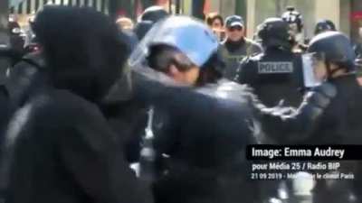 to grab a riot cop's weapon
