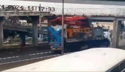 Concrete Boom truck hits overpass and knocks it over itself. Driver not injured.