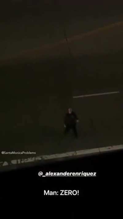 Guy rants at night standing in the middle of the road.