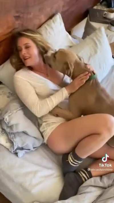 Alicia Silverstone playing with her dog
