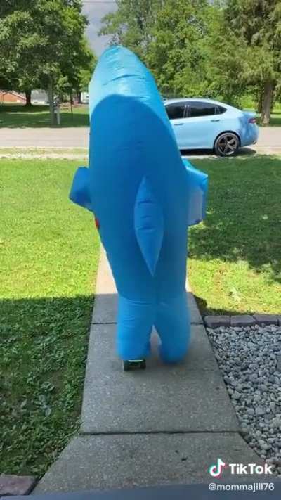 Mother filming daughter trying to longboard in crocs &amp; a shark suit
