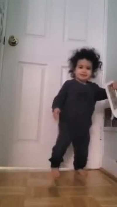 Kid makes self dizzy, bumps into wall and then proceeds to throw plastic object at father recording