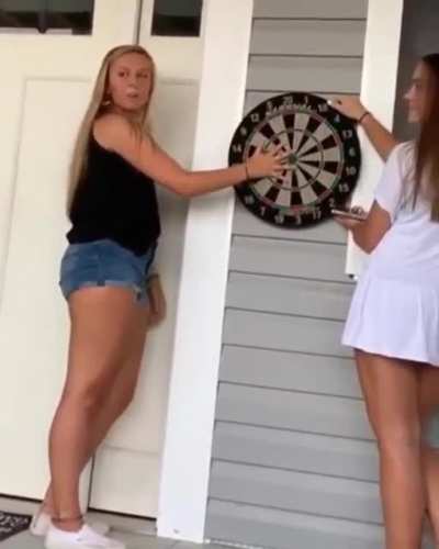 playing darts while holding the board