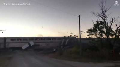 Amtrak train slams into a semi hauling vehicles, sending vehicles flying