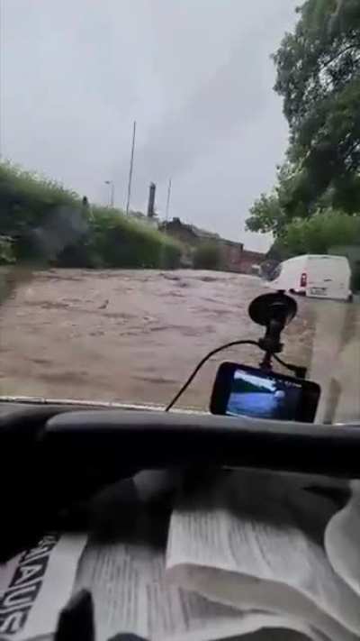 German idiot laughs at the car in front of him, proceeds to follow into the floods