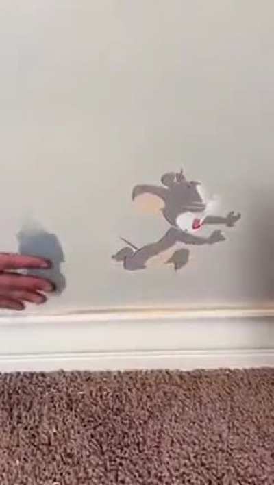 This man drawing a Tom and Jerry figure on the wall