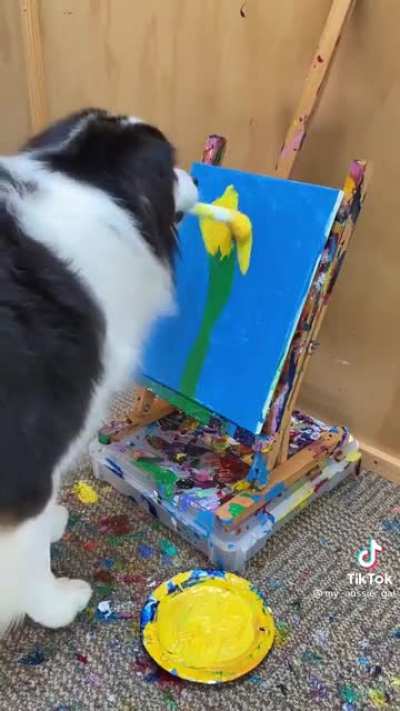 Watch this cute dog paint a sunflower!